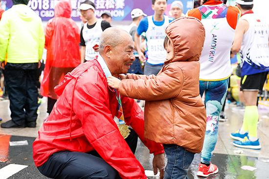 孙子给爷爷挂牌。视觉中国 图