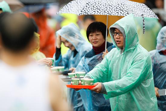 志愿者为跑友准备茶点。视觉中国 图