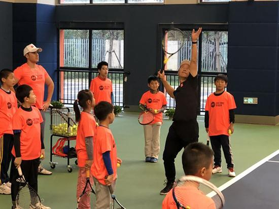 张德培指导小朋友打球。