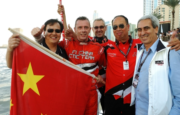 2014赛季，国际摩联F1委员会委员李浩杰（左一）手持国旗，祝贺中国天荣队荣膺年度总冠军