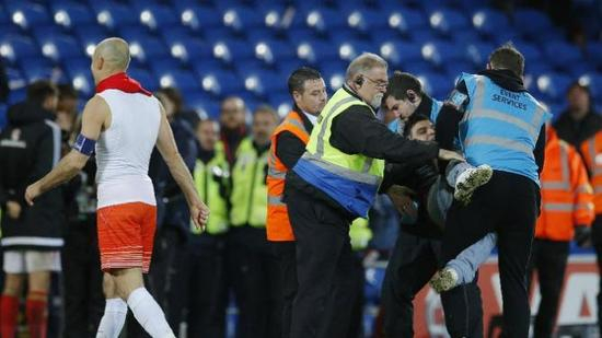 赛后，一名想和罗本合影的球迷被架走