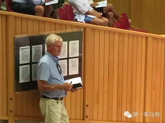 剑桥马场老板霍根爵士站在拍卖场展示台旁边紧张地观察马匹出售情况