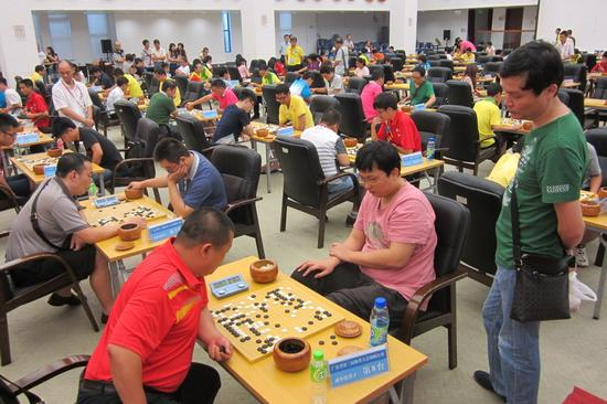 2013年林斯达（右二）代表汕头参加广东省第三届体育大会围棋赛，教练蔡建鹏旁观