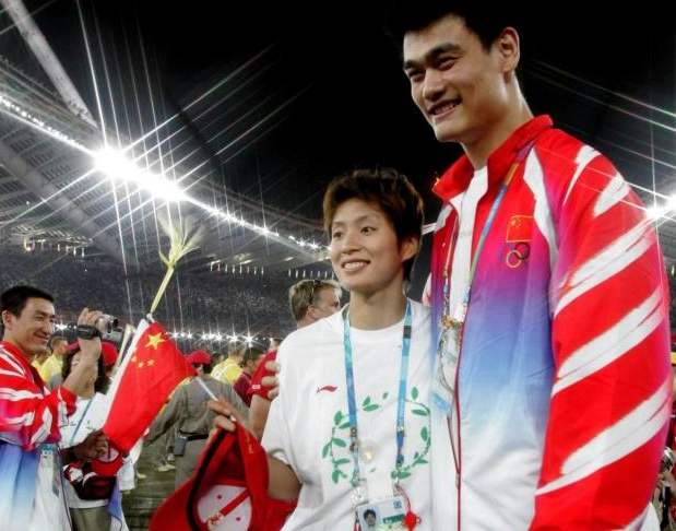 图为2004年8月29日，姚明和叶莉在雅典奥运会闭幕式上幸福相依。