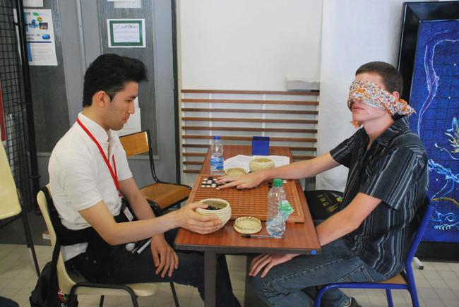 　　日本盲人棋手在围棋大会上，用特制的棋具与人对局。对面的欧洲小伙子也体验盲棋的感觉，两人公平对战。