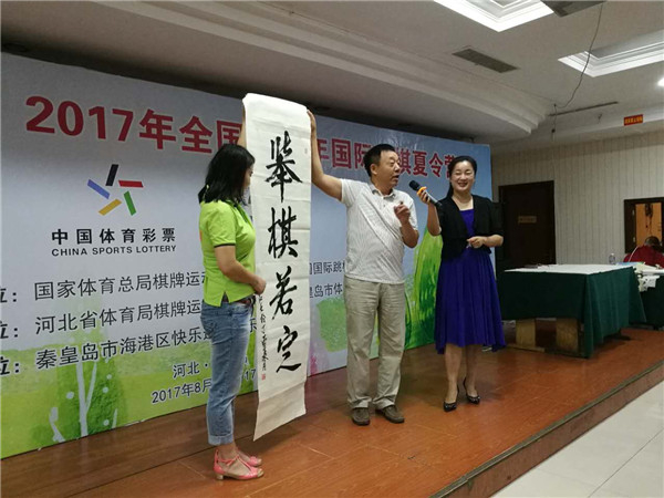 　　香港、澳门特别行政区区旗、区徽的设计者肖红教授现场挥毫泼墨，为小营员们书写“举棋若定”并送上祝愿