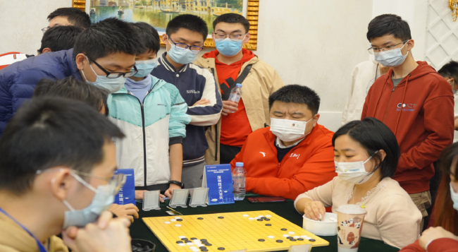 深圳市群众体育促进中心主任张文东职业九段（右三）为参赛选手赛后复盘指导。