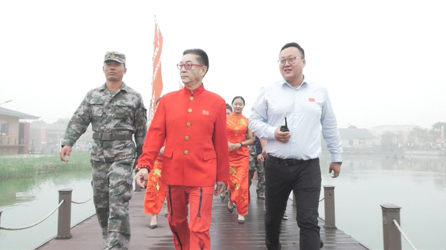 垂钓杂志社执行社长李昊千（右一）引领六小龄童走往嘉宾钓位