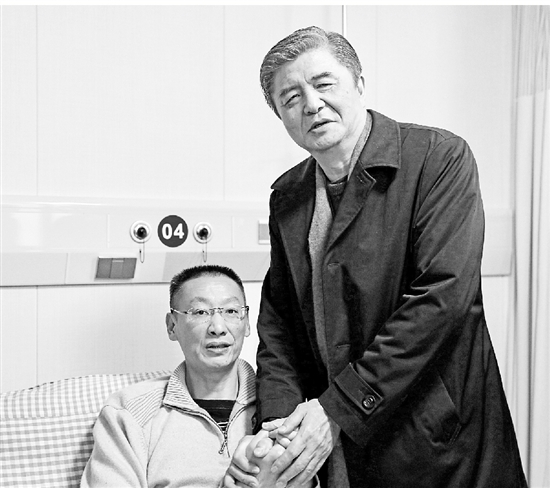 汪嘉伟握着郑亮的手。