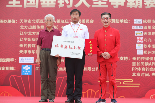 　　原农业部副部长、中国休闲垂钓协会荣誉主席齐景发（左一）向西堤头镇授予“中国西堤头镇·休闲垂钓小镇”名牌称号，六小龄童（右一）向西堤头镇授予相关荣誉证书，天津市北辰区西堤头镇党委书记李国春接收牌匾及证书。