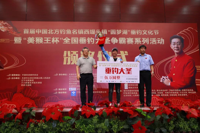 　　辽宁出版集团党委副书记赵庆国（左一）和天津市北辰区西堤头镇党委书记李国春（右一）为冠军钓手“垂钓大圣”杨泽吏颁奖