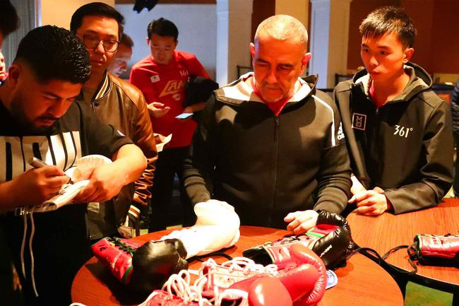 佩德罗和对手的教练在检查选手使用的拳套