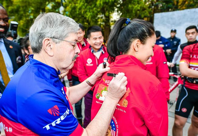 图为大使在同仁堂健康现场工作人员服装上签名留念。