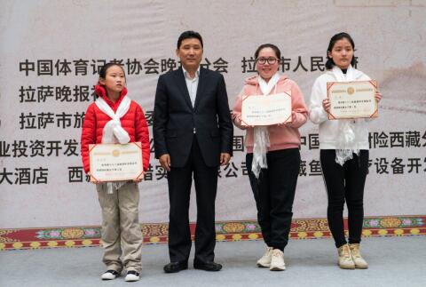 　　拉萨市委副书记、市长果果（左二）为女子组冠军李小溪（右一）、亚军郑璐（右二）和季军修昱瑾（左一）颁奖。