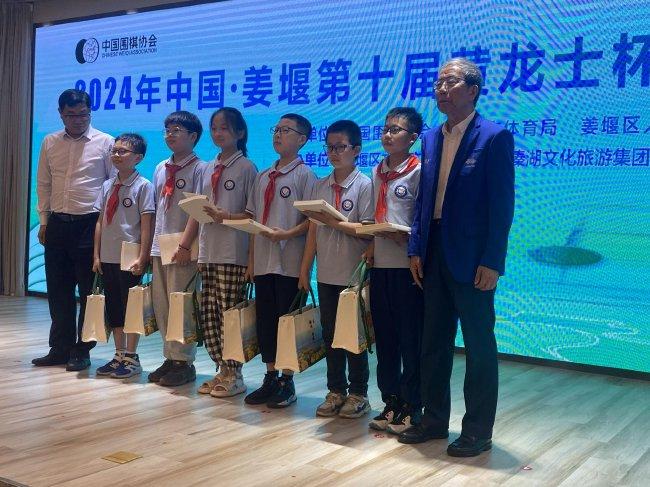 中国围棋协会领导、泰州市体育局领导向小棋手赠送书籍、围棋。