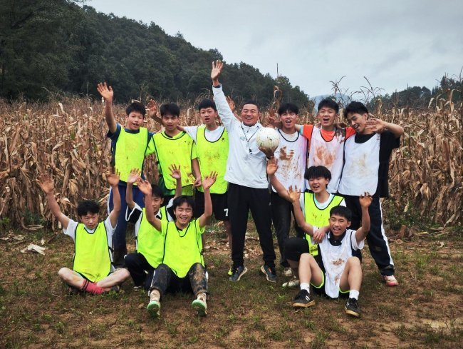 欧阳谦校长和学生们在玉米地足球场上