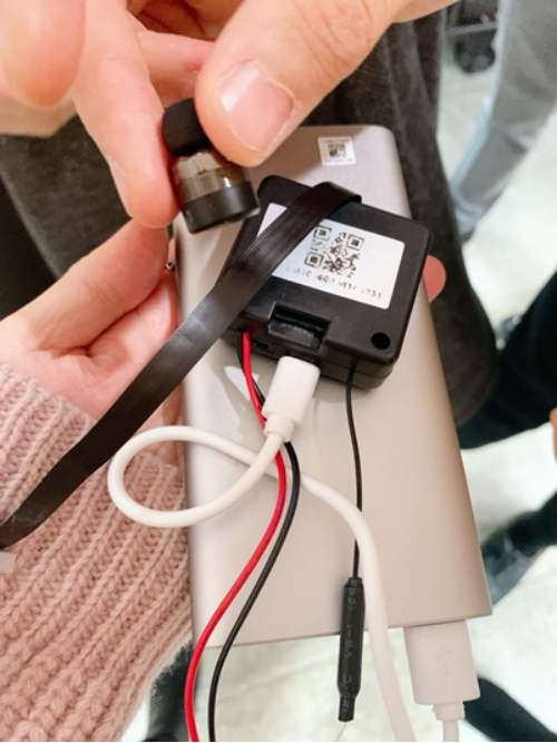 作弊者使用过的耳机和相机辅助电池。当时，作弊者将此耳机塞进他的左耳，并用绷带作了伪装