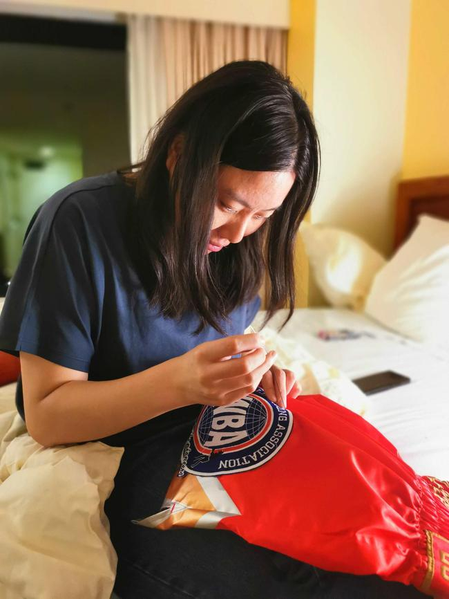 团队中的边梦頔在给徐灿缝比赛裤子上的WBA标识