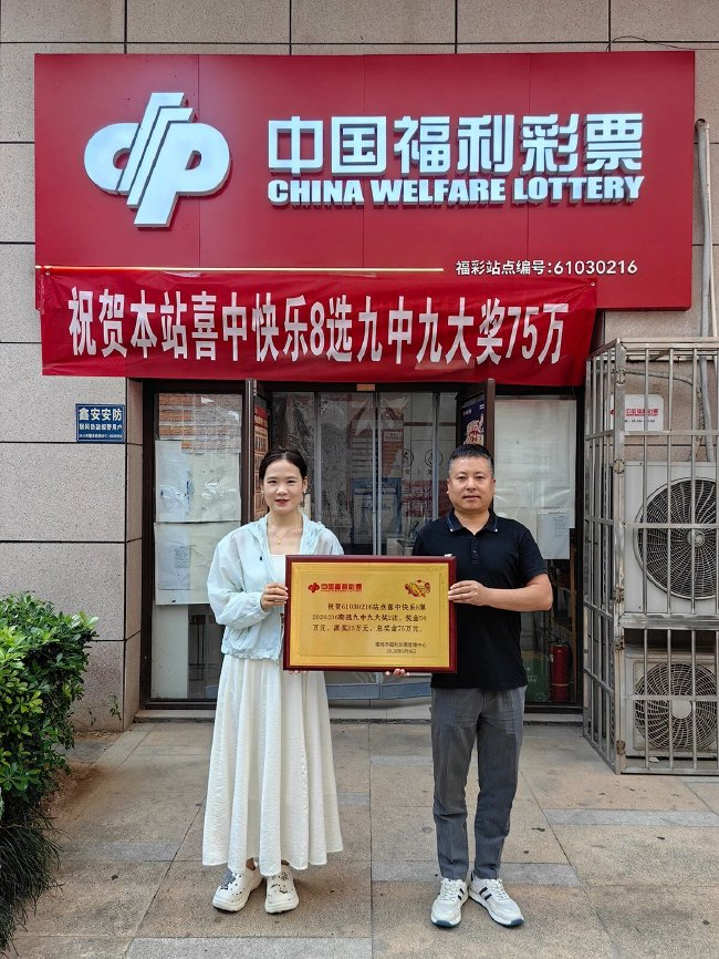 宝鸡市福彩中心工作人员（右一）为中奖站点颁发幸运投注站奖牌