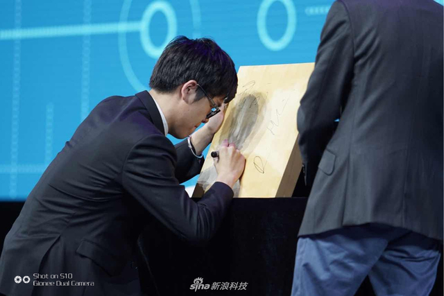 柯洁在棋盘上签名