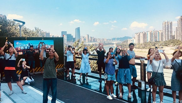 李子坝轻轨站拍摄轻轨“穿楼”景观的人群（刘向南 摄）