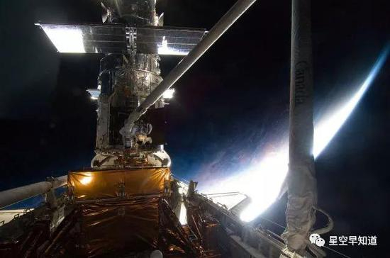 哈勃望远镜正在进行第四次太空维修与升级工作，背后的地平线上，即将迎来日出&nbsp;&nbsp;来源：NASA