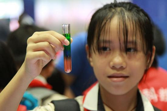 ▲一名小学生在认真观察试验产生的现象