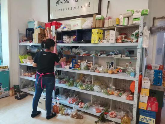 武汉一位团长将团购提货点设在自己家中，正在对团购商品进行分类 图片来源：每经记者 张明双 摄