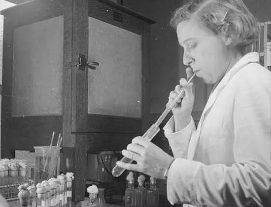 一位实验员正在吮吸血液样品