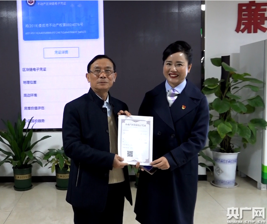 拿到全国首张不动产区块链电子凭证的娄底居民朱鹏涛（左）&nbsp;央广网记者邓文辉摄&nbsp;