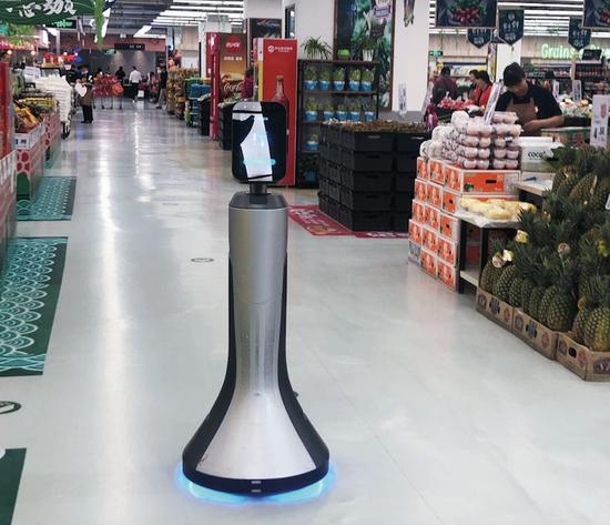 AI机器人导购员“豹小秘”正在 引导顾客到达指定的购物区。 摄影/本刊记者 吴琼