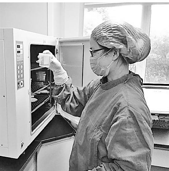 实验室人员取出样本检查。省精子库供图