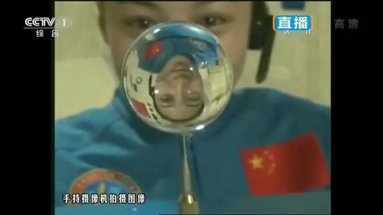 水球后的王亚平，形成了可爱的倒影（图片来源：搜狐网）