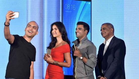 小米印度负责人Manu Jain 在发布会上和印度女演员合影。 图片：PTI Photo by Manvender Vashist