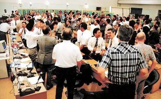 中外科技人员在发射成功后互相祝贺