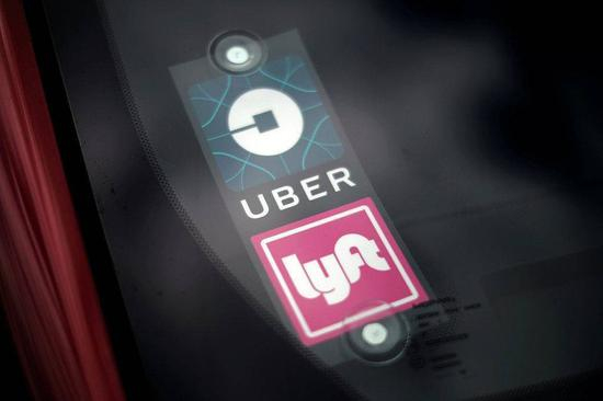 汽车挡风玻璃上的 Uber 和 Lyft 标识 | 视觉中国