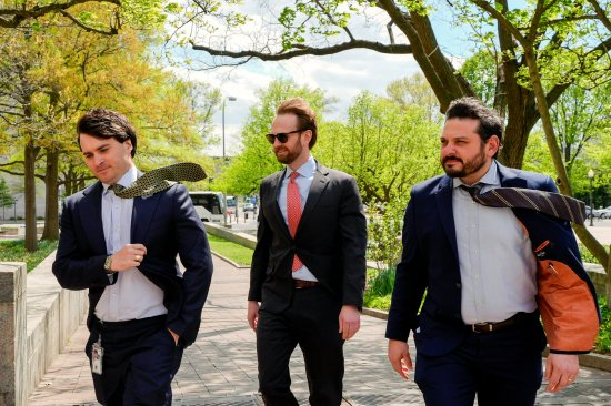 4 月，联邦贸易委员会发言人乔・西蒙森（Joe Simonson，左）和参谋长加里・巴尼特（Gary Barnett，右）在华盛顿联邦法院外陪同弗格森。