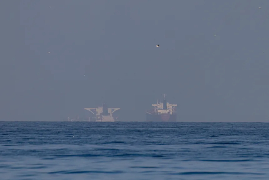 2026 年 3 月 22 日，阿拉伯联合酋长国哈伊马角北部、霍尔木兹海峡附近的海湾区域，多艘商船停泊于此。