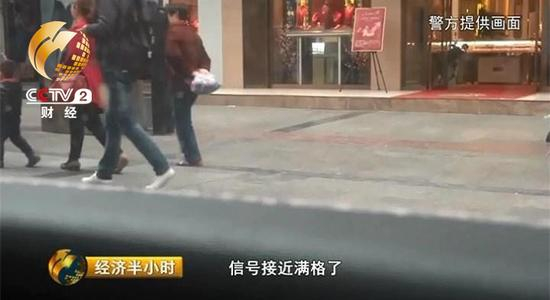 一名背着书包的男子刚好从车边路过，此时伪基站发出的信号接近满格。