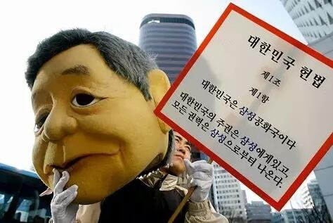 抗议财阀的韩国示威者，牌子上写着“大韩民国是三星共和国，大韩民国的主权属于三星”。