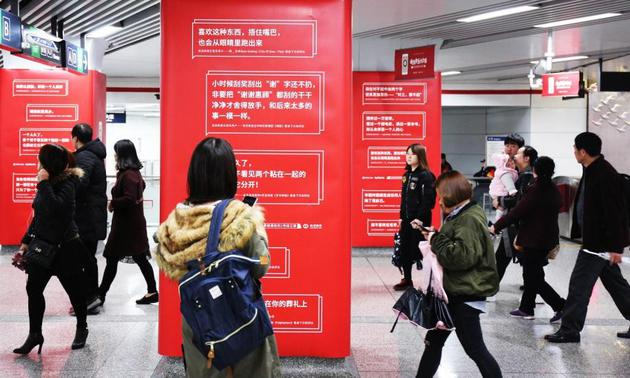 在江陵路地铁站站厅里阅读网易云音乐乐评的乘客