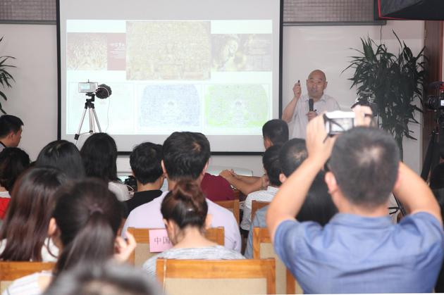 中国文物保护基金会秘书长詹长法向观众展示千手观音造像的变迁与重生