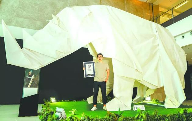 刘通和他的作品《白犀牛》（该作品是世界最大的折纸白犀牛，获吉尼斯世界纪录）