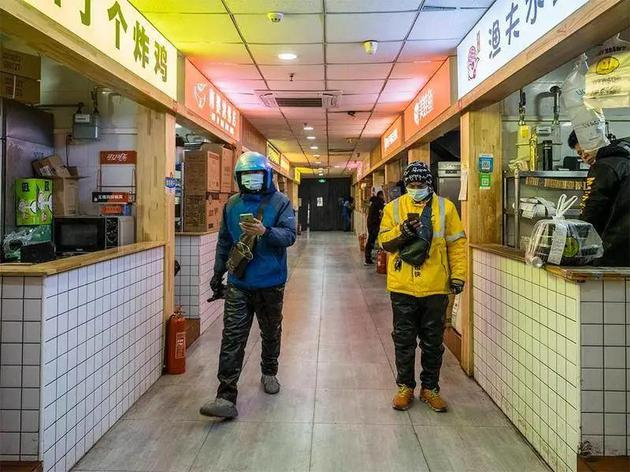 不同平台的骑手，在搜寻订单所在的幽灵厨房。摄影 / 朱玲玉