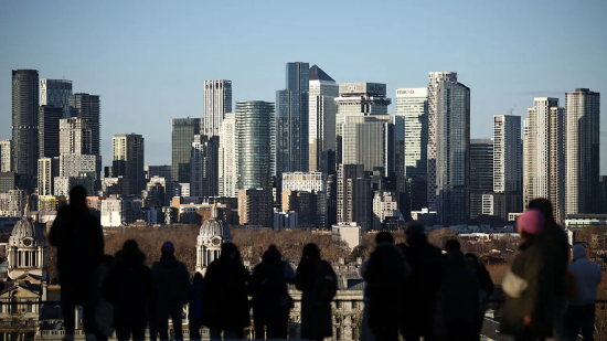 2026 年 1 月 2 日，英国伦敦天气晴朗但气温偏低，人们在格林威治公园的观景台游览，远处是金丝雀码头金融区。