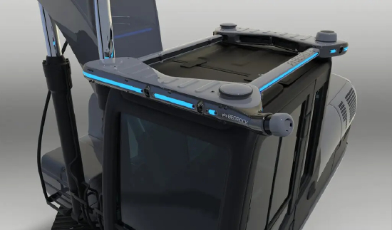 一台灰黑色的设备，顶部边缘环绕着细蓝灯，印有大写的 “Bedrock” 字样，安装在工程车辆的驾驶舱上。Bedrock 的传感器技术与 Waymo 自动驾驶出租车所用技术类似。