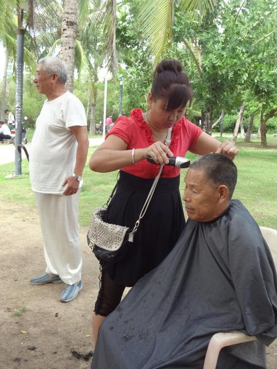  来自哈尔滨的张淑娟，陪母亲南下过冬养身体，闲暇之余，重操旧业，在白鹭公园理发，做生活补贴。