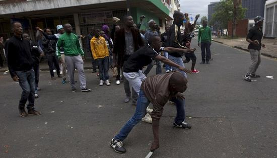 当地时间2015年4月14日，南非德班，外国人持刀自卫。据报道，南非针对外国人的暴力袭击和排外骚乱愈演愈烈，在南非多个城市蔓延，数百家外国人商店被打砸哄抢，数千名外国人流离失所。　　