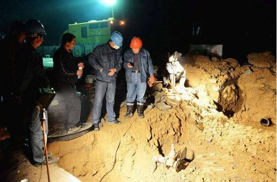 图为：2013年11月22日晚，抢修人员在山东青岛黄岛管线泄漏起火爆炸现场抢险施工。