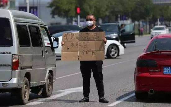 8月13日，天津滨海爆炸事故致部分医院物资药品短缺，市民志愿者烈日下路边举牌求帮助。东方IC